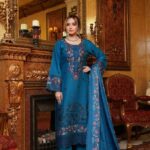 Woman wearing Mahi teal blue Dhanak suit with floral embroidery and printed wool shawl