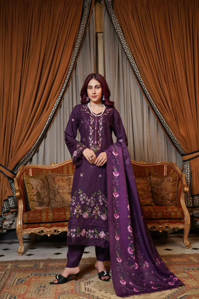 munira-mahi-vol-18-plum-embroidered-dhanak-suit-front Plum-colored embroidered Dhanak suit featuring floral embroidery on the neckline, sleeves, and hem, paired with matching trousers and a printed plum shawl.